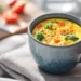 Microwave mug omelette with peppers, spinach, and cheese, served in a white ceramic mug.