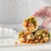 Budget bean burritos with black beans, rice, cheese, and vegetables on plate with salsa