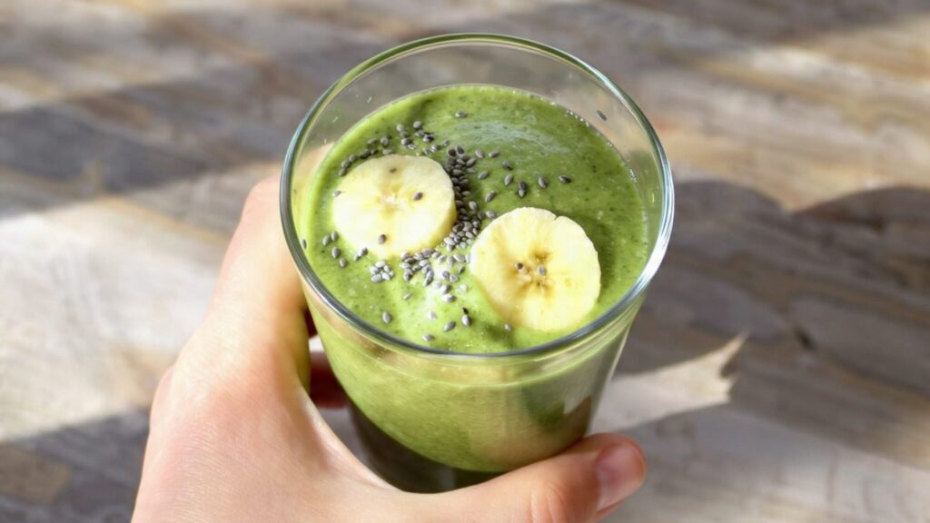 Quick fiber smoothie with spinach, banana, and mixed berries in a tall glass with a reusable straw