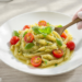 Pesto pasta salad with cherry tomatoes, quick vegetarian dish served fresh or chilled.