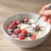 Quick healthy breakfast recipes for gut health with yogurt, berries, avocado toast, and lemon water on a white kitchen table.