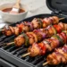 BBQ chicken kabobs on the grill with bell peppers and onions, glazed with smoky barbecue sauce on a white background