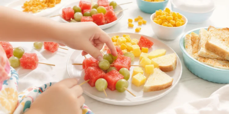Quick beach snacks for kids with fruit, finger sandwiches, veggie sticks, and portable treats in colorful containers.