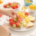 Quick beach snacks for kids with fruit, finger sandwiches, veggie sticks, and portable treats in colorful containers.
