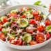 Easy tomato cucumber salad with red onion, fresh herbs, and olive oil dressing — quick healthy summer side dish