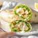Grilled chicken Caesar wraps sliced in half and stacked, filled with romaine, parmesan, and creamy Caesar dressing.