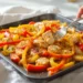 Sheet pan chicken fajitas with roasted chicken strips, bell peppers, and onions.