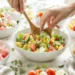 A collection of colorful easy summer salads with fresh vegetables, fruits, and greens in bright ceramic bowls.