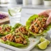 Grilled chicken lettuce wraps on a neutral surface, shown at a 45-degree angle.