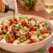 Caprese pasta salad with mozzarella, cherry tomatoes, basil in bowl