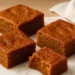 Assortment of autumn desserts including apple cinnamon cake, pumpkin cookies, and caramel treats on a wooden table